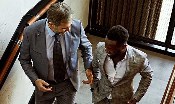 Two businessmen walking down staircase